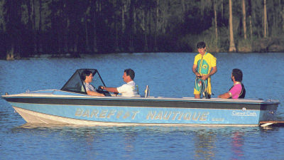 People in Barefoot Nautique Boat on lake